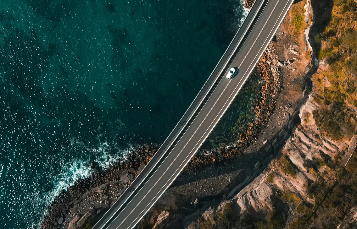 Car Driving on Road Along Coast