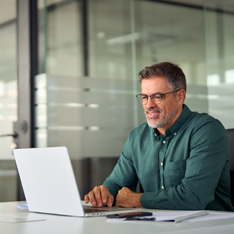 happy male reading document on computer