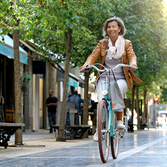 happy female riding bike on city street